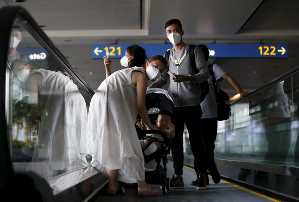 Passengers wearing masks to prevent contracting Middle East Respiratory Syndrome (MERS) ride on a travelator upon arrival at Incheon International Airport in Incheon, South Korea, June 2, 2015. South Korea on Tuesday reported its first two deaths from an outbreak of MERS that has infected 25 people in two weeks, as public alarm grew and officials scrambled to contain the outbreak. REUTERS/Kim Hong-Ji      TPX IMAGES OF THE DAY